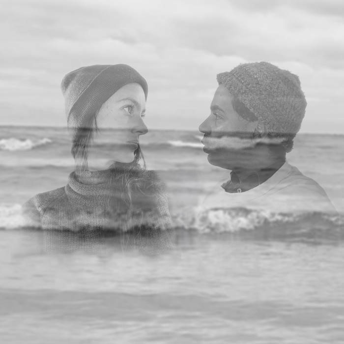 Black and white image of two people gaze longingly at each other, their faces fading over an image of a shoreline.